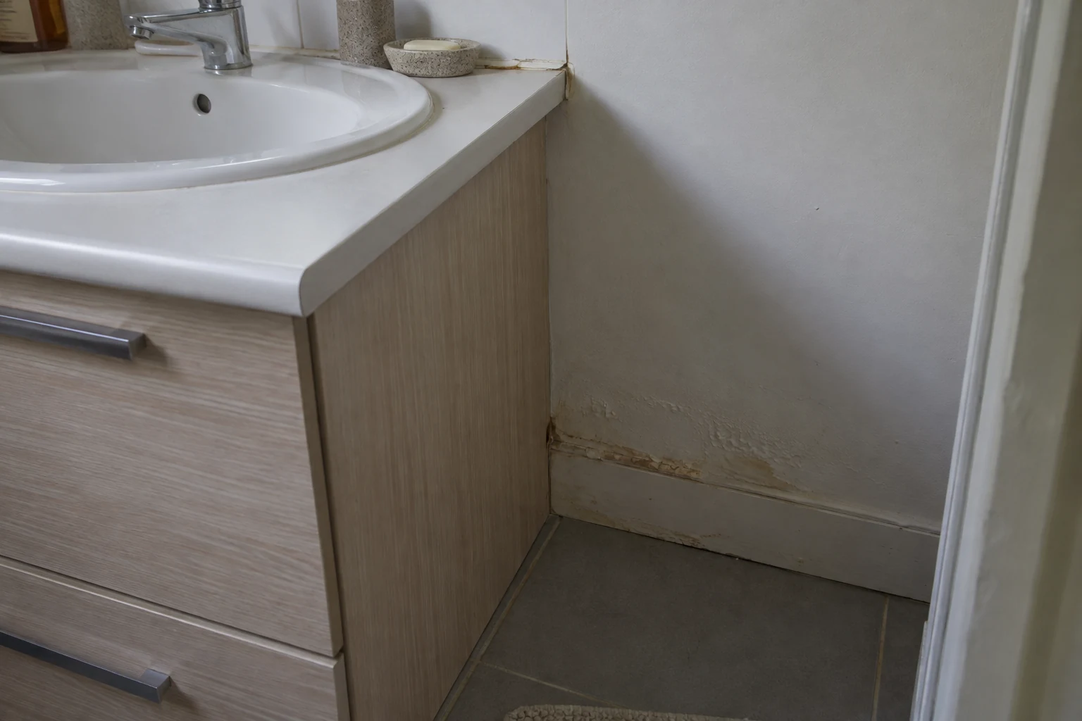Joint périphérique de lavabo dégradé et peinture abîmée au niveau de la plinthe